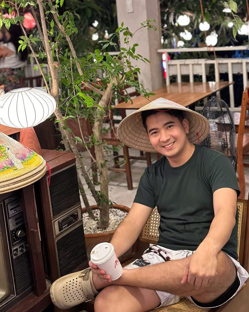 Man with Vietnamese hat enjoying coffee outdoors