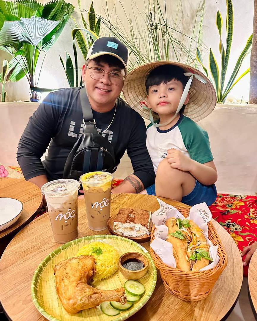 Father and son with Vietnamese hat and food spread